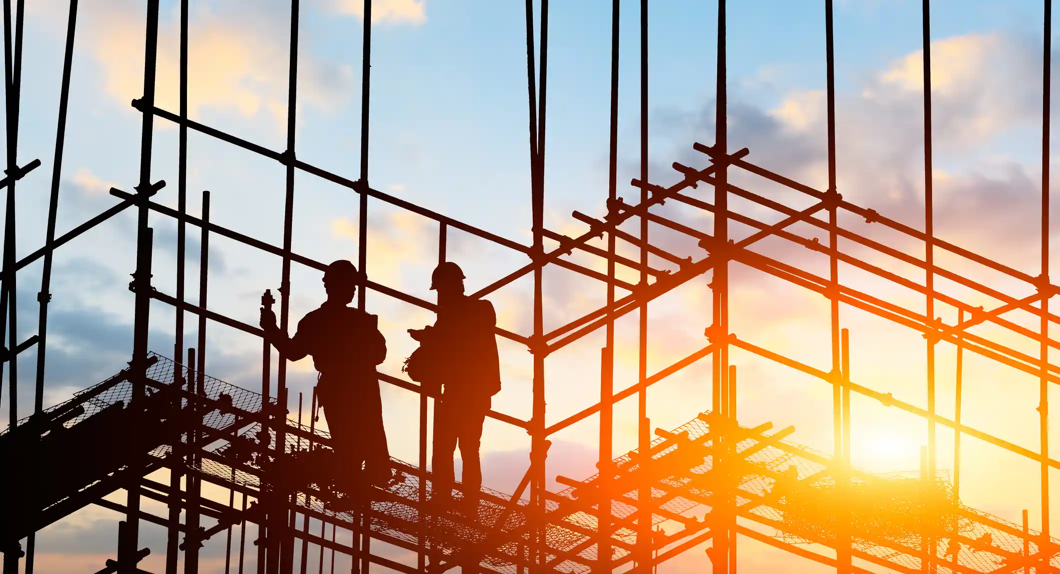 architects and engineers discussing work progress between concrete walls, scaffolds and cranes