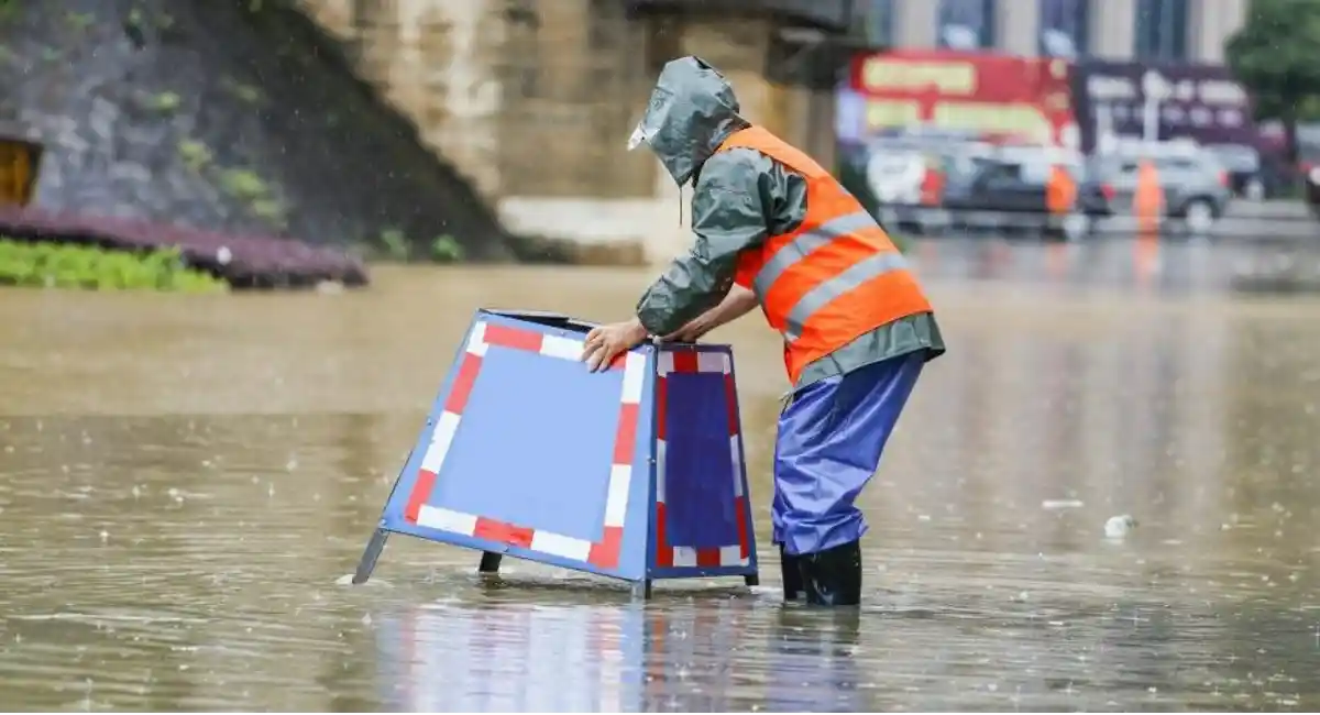 person wading through floodwaters